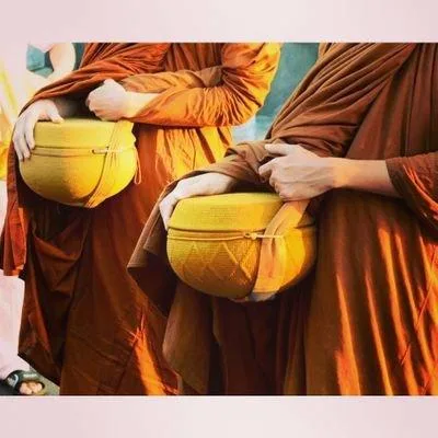 Dos bhikkhus sosteniendo sus cuencos de limosnas