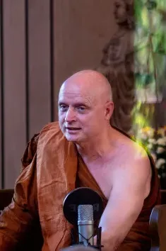 Ajahn Jayasaro dando una charla frente a un micrófono